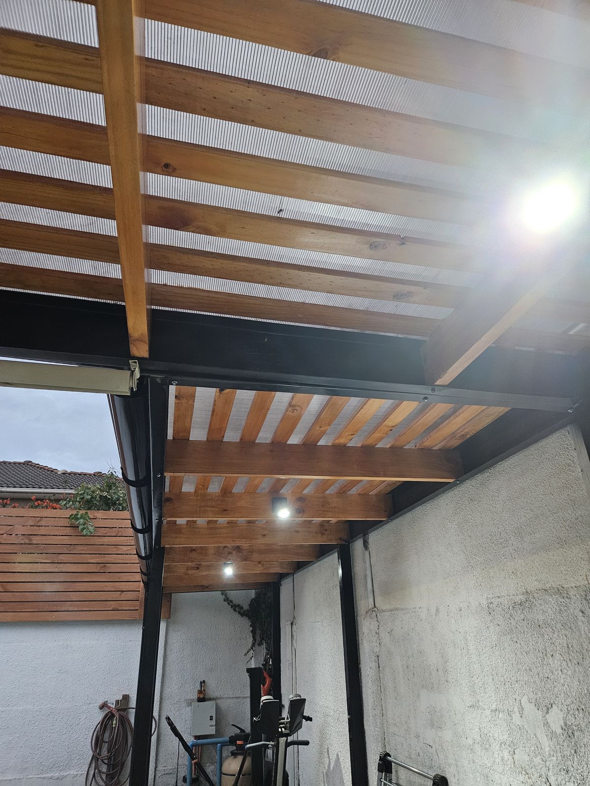 Cobertizo metálico con techo de madera e iluminación